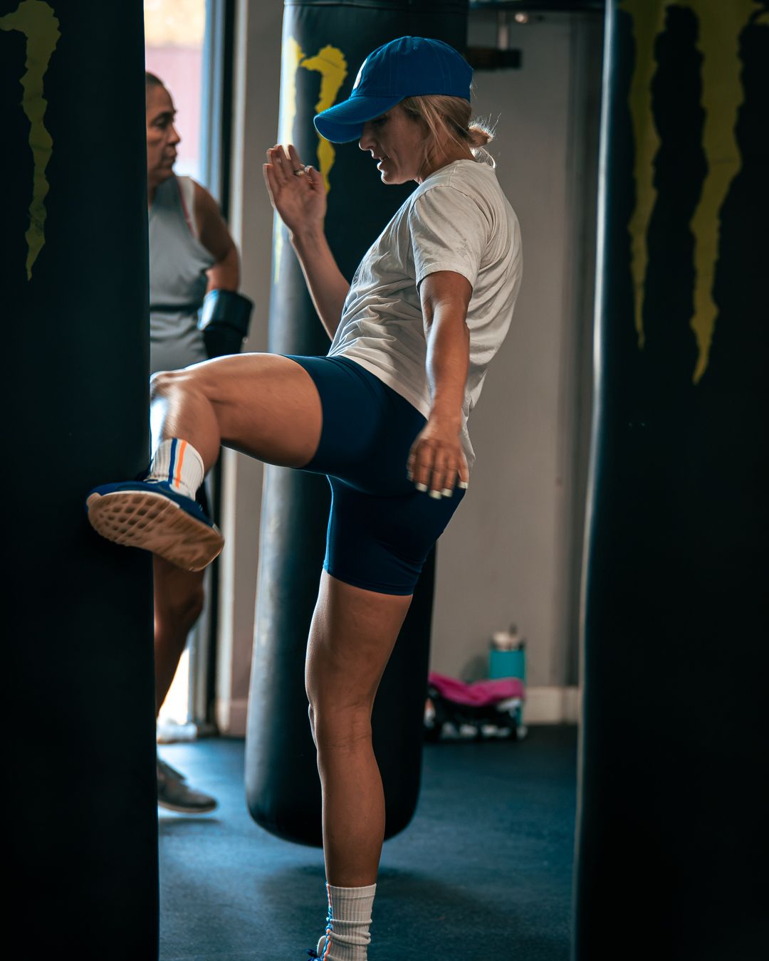 A member throwing a knee into the heavy bag