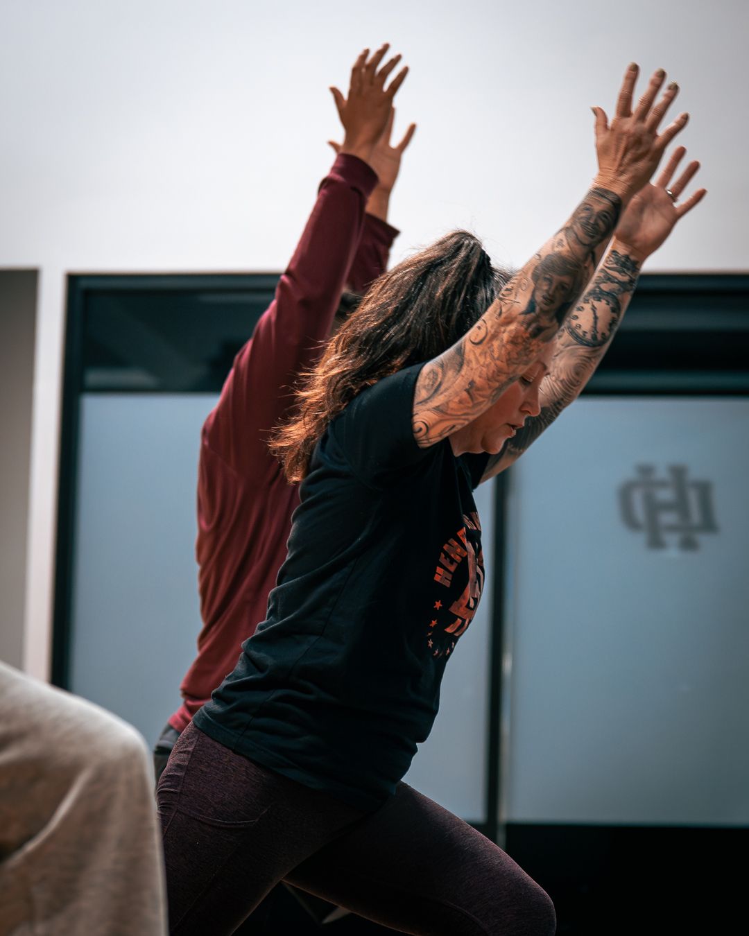 Members reaching overhead during a yoga class